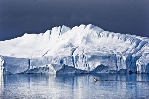 Feeling-tiny-in-Greenland-small-boat-next-to-massively-and-magestic-iceberg